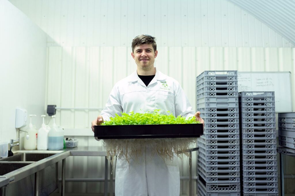 Ein junger Unternehmer präsentiert seine nachhaltig gezüchteten Pflanzen
