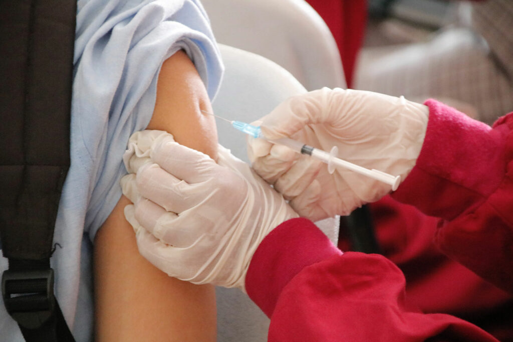 Eine Person bekommt eine Impfung in den linken Oberarm