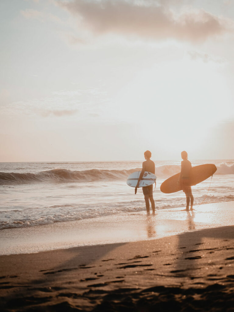 Zwei Surfer schauen auf das Meer und genießen das Leben und ihre Freizeit