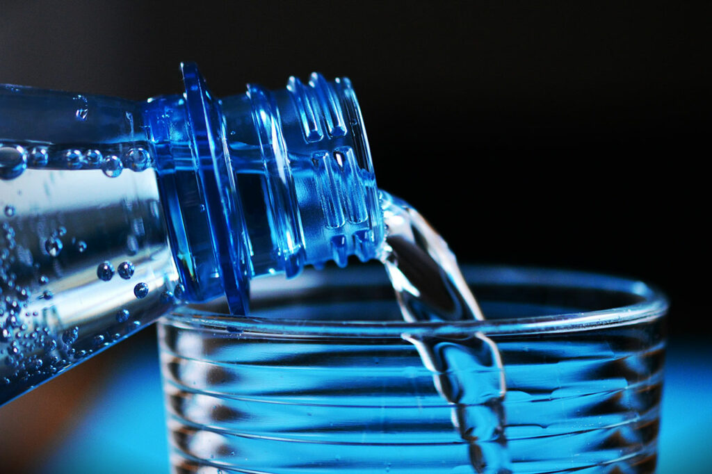 Mineralwasser wird aus einer Flasche in ein Glas gegossen