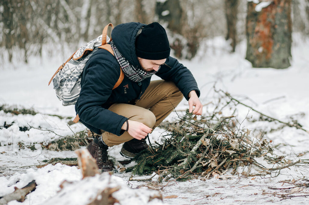 Ein Mann sammelt im Winter Leseholz vom Waldboden