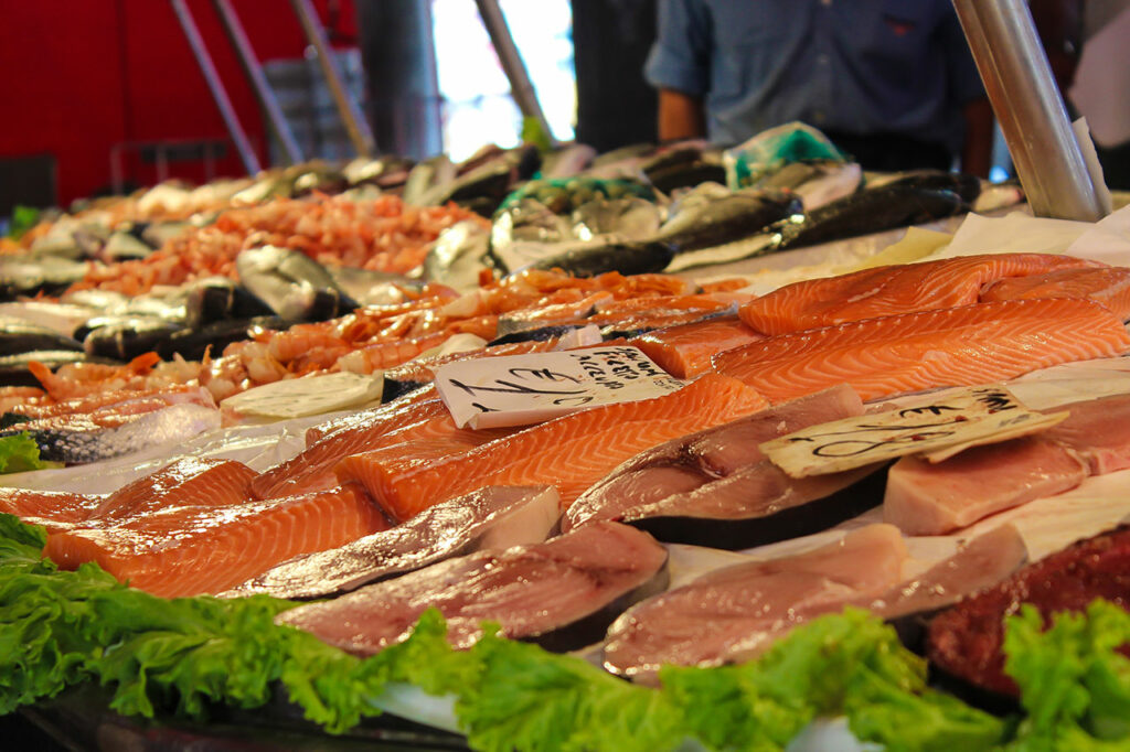 Verschiedene Arten roher Fisch liegen in einem Fischmarkt zum Verkauf aus
